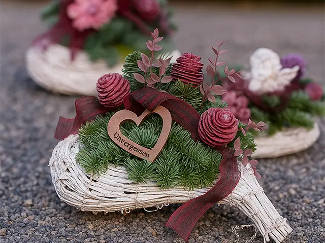 Dekoratives Grabgesteck in Herzform auf Kies