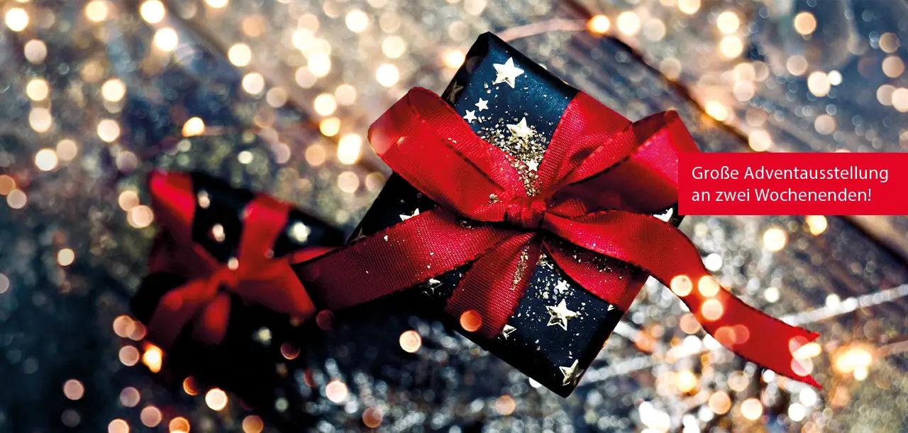 Draufsicht eines Weihnachtsgeschenkes auf stimmungsvollem Untergrund mit Glitzer und Lichtern